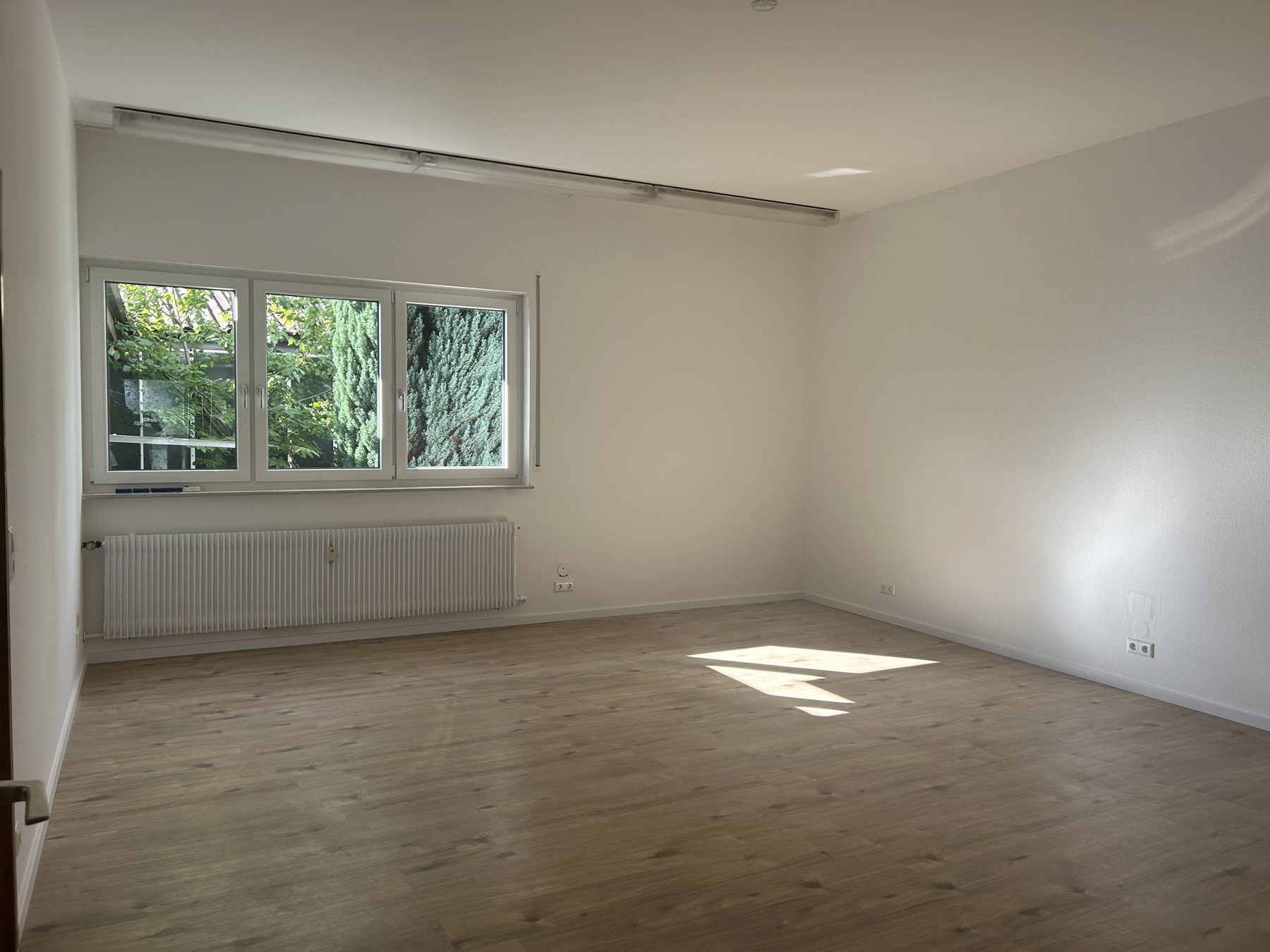 Büro mit breitem Fenster und Blick in den Garten